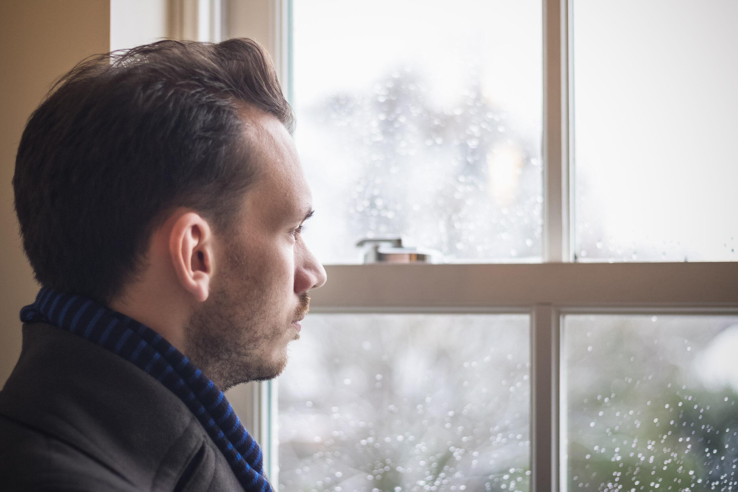 Portrait of a man looking out window